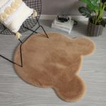 tapis en forme de tête d'ourson marron et une chaise noire metallique