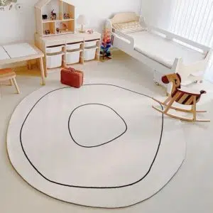 tapis rond blanc avec liseré noir , cheval à bascule et lit d'enfant blanc
