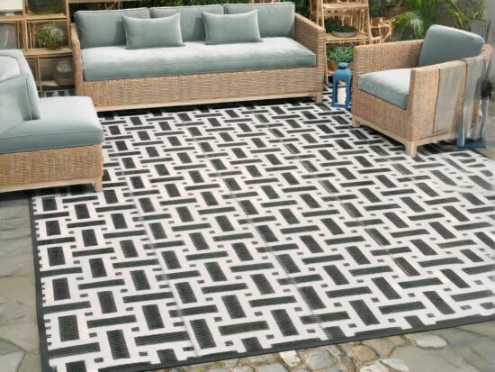 Tapis de terrasse blanc et noir avec canapé en rotin
