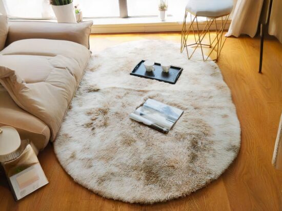 Tapis cocooning ovale avec livres a coté d'un lit