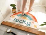 tapis de salle de bain balnc avec un arc en ciel et l'inscription lucky