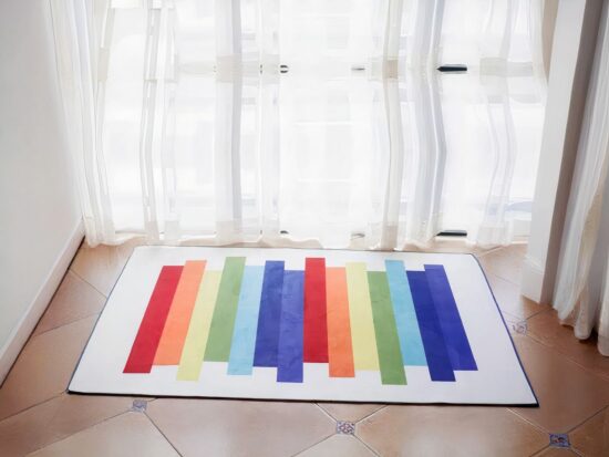 grand tapis blanc rectangulaire avec des bandes colorées au couleur de l'arc en ciel