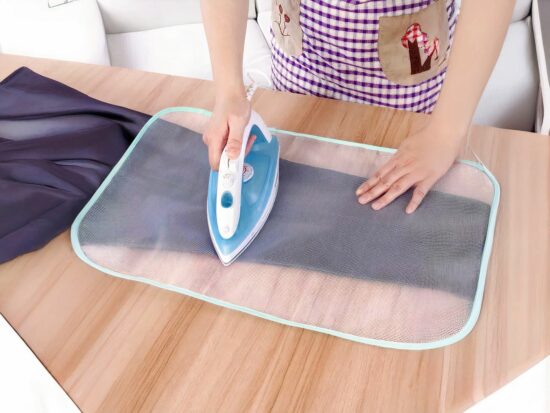 tapis de repassage avec une femme qui tient un fer à repassé sur une table en bois