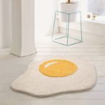 Tapis de salle de bain amusant et antidérapant en forme d'œuf sur sol blanc