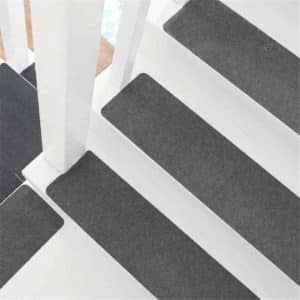 Tapis d'escalier gris avec rambarde blanche en bois