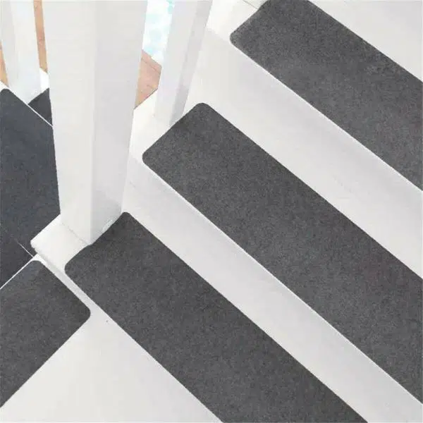 Tapis d'escalier gris avec rambarde blanche en bois