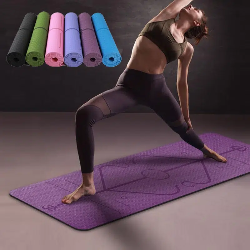 Tapis de yoga violet avec une femme en tenue de sport noire qui fait du yoga et 6 petite tapis de yoga colorés enroulés