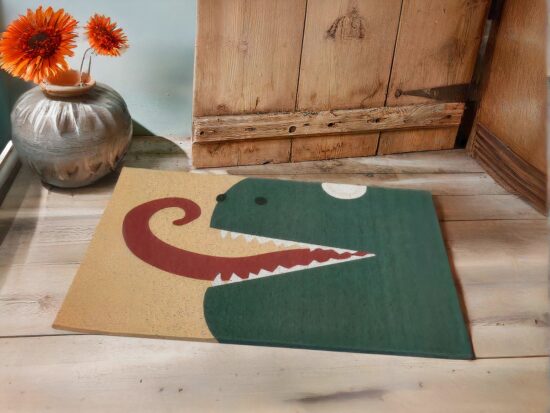 tapis dinosaure vert avec lange rouge a coté des fleurs