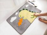 Tapis de bain dinosaure vert crache feu dans une salle de bain