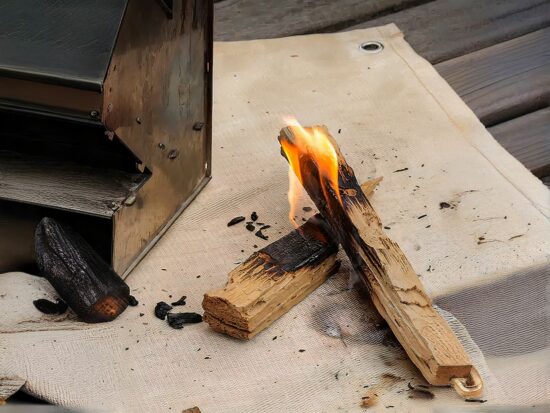 Tapis de barbecue avec de la braise incandescente et un pied de barbecue