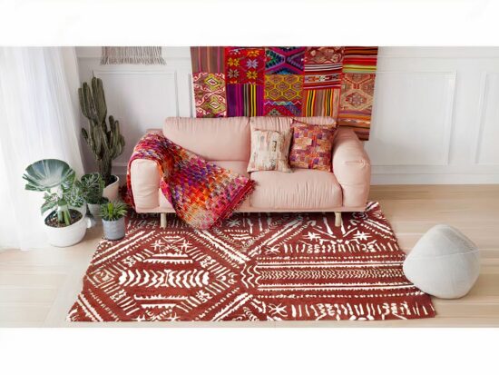 Tapis indien style ethnique rouge avec canapé rose