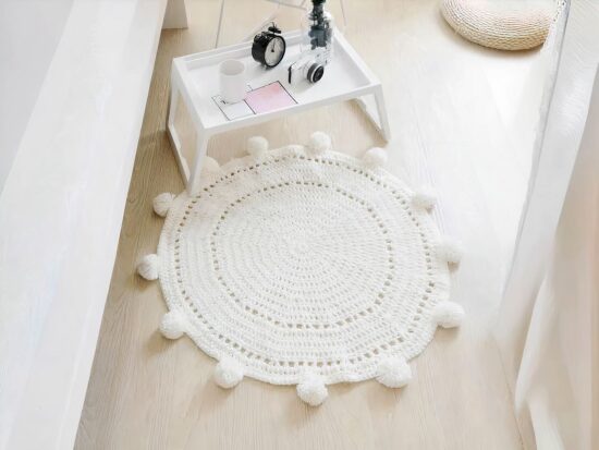 Tapis rond à pompon tricoté à la main pour enfants. Bonne qualité et très tendance dans une maison.