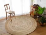 Grand tapis rond en sisal avec une chaise en bois et paille et une étagère