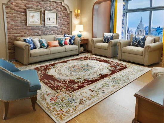 Tapis vintage floral blanc et rouge dans un gros sallon avec canapés