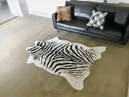 Tapis zèbre imitation de peau devant canapé noir en cuir