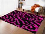 Tapis zèbre rose et noir dans un sallon devant un canapé blanc