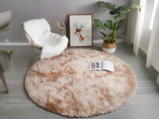 Tapis cocooning beige rond installé dans un salon au pied d'une chaise à bascule