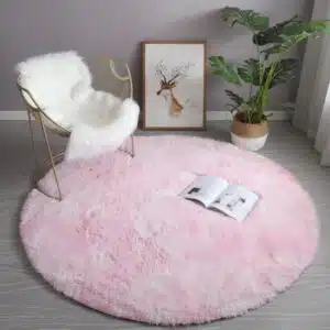 Tapis cocooning rond rose bonbon installé dans un salon aux pieds d'une chaise à bascule