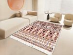 Tapis marocain rétro rectangulaire à frange avec formes géométriques rouge foncé installé dans un salon devant un canapé beige et un fauteuil assorti