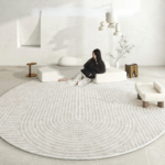 Tapis japonais doux et moelleux style japandi gris sur lequel se trouve une jeune femme caucasienne accoudée